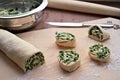 Cooking homemade buns with green onions, nettles, cheese and egg, the second step. Folding the roll with the filling and cutting
