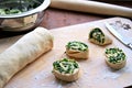 Cooking homemade buns with green onions, nettles, cheese and egg, the second step. Folding the roll with the filling and cutting