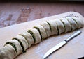 Cooking homemade buns with green onions, nettles, cheese and egg, the second step. Folding the roll with the filling and cutting