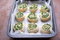 Cooking homemade buns with green onions, nettles, cheese and egg, the third step. Finished shaped buns in the pan for baking.
