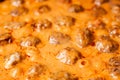 Cooking homemade meatballs in a frying pan in a sauce of tomatoes and sour cream. Close-up macro. Food background Royalty Free Stock Photo