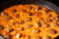 Cooking homemade meatballs in a frying pan in a sauce of tomatoes and sour cream. Close-up macro. Food background Royalty Free Stock Photo