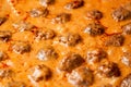 Cooking homemade meatballs in a frying pan in a sauce of tomatoes and sour cream. Close-up macro. Food background Royalty Free Stock Photo