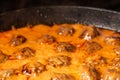 Cooking homemade meatballs in a frying pan in a sauce of tomatoes and sour cream. Close-up macro. Food background Royalty Free Stock Photo