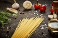 Tomatoes garlic salt olive peppers and pasta on a black table Royalty Free Stock Photo