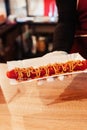 Close-up of grilled sausages in a cafe, which are fried to a brown crust. Cooking ingredients for a hot dog. Vertical photo