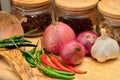 Cooking ingredients. Spice and herbs with onion and garlic on wooden board Royalty Free Stock Photo