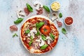 Cooking Italian pizza with tomato sauce, fresh tomatoes, cheese, mushrooms, salami slices  and basil . Royalty Free Stock Photo