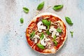 Cooking Italian pizza with tomato sauce, fresh tomatoes, cheese, mushrooms, salami slices and basil . Royalty Free Stock Photo