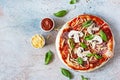 Cooking Italian pizza with tomato sauce, fresh tomatoes, cheese, mushrooms, salami slices  and basil . Royalty Free Stock Photo