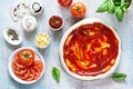 Cooking Italian pizza with tomato sauce, fresh tomatoes, cheese, mushrooms, salami slices and basil . Royalty Free Stock Photo