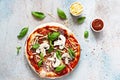 Cooking Italian pizza with tomato sauce, fresh tomatoes, cheese, mushrooms, salami slices and basil . Royalty Free Stock Photo