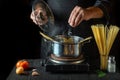 Cooking Italian spaghetti in the restaurant kitchen. The chef adds salt to Stock pot of boiling water. Free advertising space Royalty Free Stock Photo