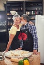 Cooking, kiss and senior couple in kitchen at home with dough, flour and ingredients for meal. Happy, food and elderly Royalty Free Stock Photo