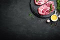 Cooking on kitchen table fresh raw pork marbled steaks on black background Royalty Free Stock Photo
