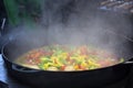 Cooking vegetables in large cast iron cauldron Royalty Free Stock Photo