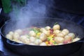 Cooking vegetables in large cast iron cauldron Royalty Free Stock Photo