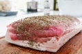 Cooking. A large piece of pork meat for grilling in spices. Modern minimalistic bright kitchen, close-up photo