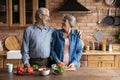 Loving mature couple vegans talk laugh cook food at kitchen Royalty Free Stock Photo