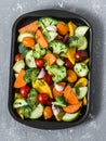 Cooking lunch. Raw fresh vegetables on a baking sheet. Sweet potato, zucchini, sweet pepper, cherry tomatoes, garlic, broccoli Royalty Free Stock Photo