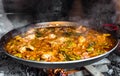 Cooking and making a traditional Spanish Paella over open fire