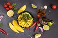 Cooking mango salsa - sliced chopped ingredients in a black ceramic bowl