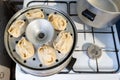 Cooking of Manti dumpling in metal steamer pot