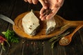 Cooking marinated herring from catfish fish steaks with aromatic spices by the hands of a chef on the kitchen table. Fish diet Royalty Free Stock Photo