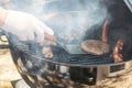 Cooking meat for burgers and cheeseburgers, sausages for hot dogs, buns on a grill with burning coals. Royalty Free Stock Photo