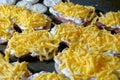 Cooking meat with cheese in French. The meat baked in the oven lies on a black metal baking sheet