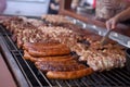 Cooking meat dishes in a summer restaurant on the street. Assorted delicious grilled meat with vegetables over charcoal barbecue Royalty Free Stock Photo