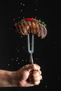 cooking meat steak and adding salt, grilled steak. vertical image. copy space for text Royalty Free Stock Photo