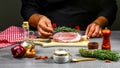 Cooking meat steak, vegetables and spices with by chef hands on wooden background. Food recipe concept Royalty Free Stock Photo