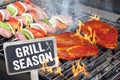 Meat, steaks and sausages on a bbq grill outside with grill season Royalty Free Stock Photo