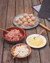 Cooking meatballs with ingredients on the plates, plates and cutlery on the board table