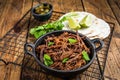 Cooking of mexican pork carnitas taco. Wooden background. Top view