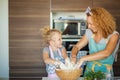 Mother and child daughter girl having fun while making dinner at the kitchen. Royalty Free Stock Photo