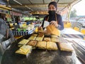 A woman is cooking murtabak or paratha with filling at the local stall in Malaysia.
