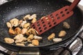 Cooking mussels in a frying pan on a kitchen stove