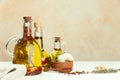 Cooking oil with different spices and herbs in jugs on white wooden table. Space for text Royalty Free Stock Photo