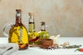 Cooking oil with different spices and herbs in jugs on white wooden table. Space for text Royalty Free Stock Photo