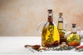 Cooking oil with different spices and herbs in jugs on white wooden table. Space for text Royalty Free Stock Photo