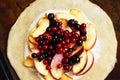 Cooking open pie or galette with apples and berries