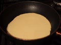 Cooking a pancake in a frying pan.