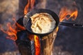 Cooking pancake in a pan on the fire of a Finnish candle