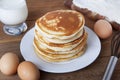 Cooking pancake on wooden background top view ingredients for making pancakes: milk, eggs, flour.