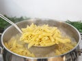 Cooking Pasta pour the penne pasta into a metal pot of boiling water. Boiled penne on a steel colander, in a cooking class Royalty Free Stock Photo