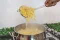 Cooking Pasta pour the penne pasta into a metal pot of boiling water. Boiled penne on a steel colander, in a cooking class Royalty Free Stock Photo