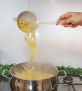 Cooking Pasta pour the penne pasta into a metal pot of boiling water. Boiled penne on a steel colander, in a cooking class Royalty Free Stock Photo