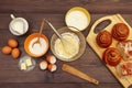 Cooking pastries from ingredients to fresh buns on wooden table. View from above